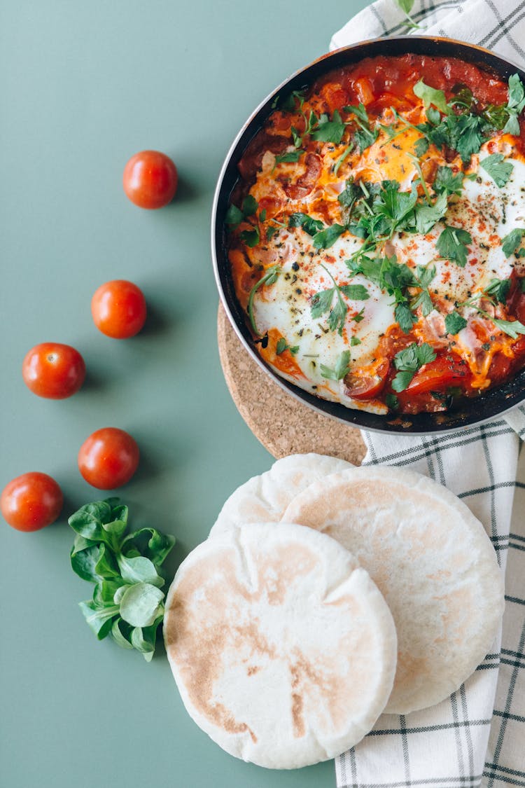 Shakshouka And Pita Breads On The Table