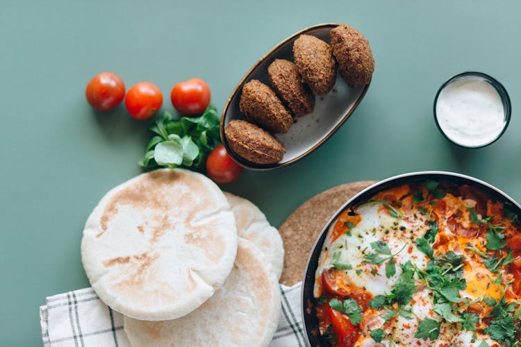 Falafel In A Bowl And Bread Near A Pan With Cooked Food