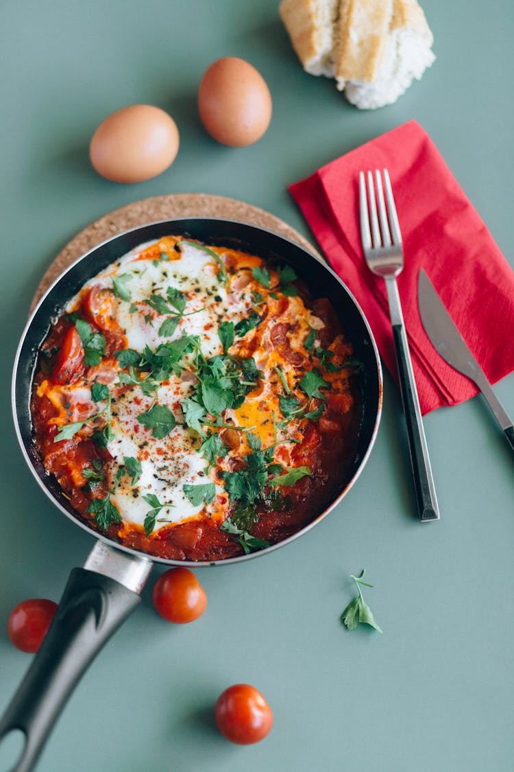 Fork And Knife Beside A Pan With Cooked Food