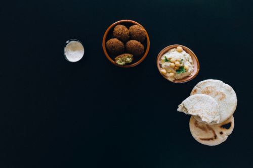 Free A delicious spread of falafel, hummus, and pita bread on dark background. Stock Photo
