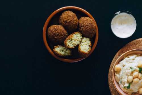 Free Delicious falafel and creamy hummus served with a side of tzatziki sauce, perfect for vegan meals. Stock Photo