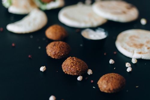 Free Home-cooked falafel and pita bread with tahini sauce on a dark table. Stock Photo