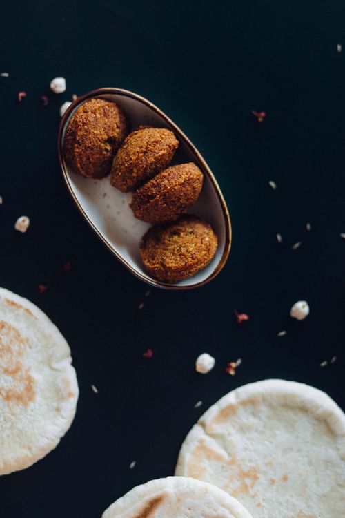 Free Close-up shot of crispy falafel served with fresh pita bread on a dark background. Stock Photo