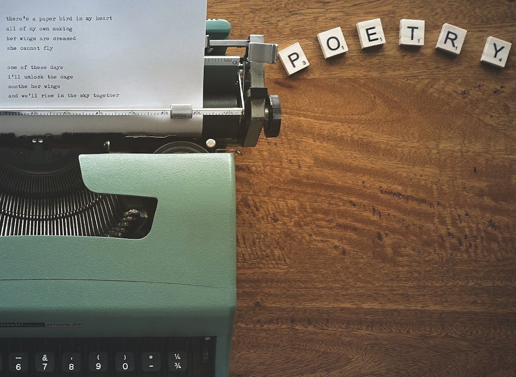 Green and Black Typewriter on Brown Wooden Table