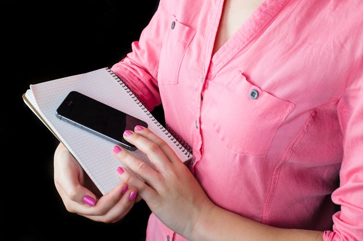 Person Holding Phone And Notebook