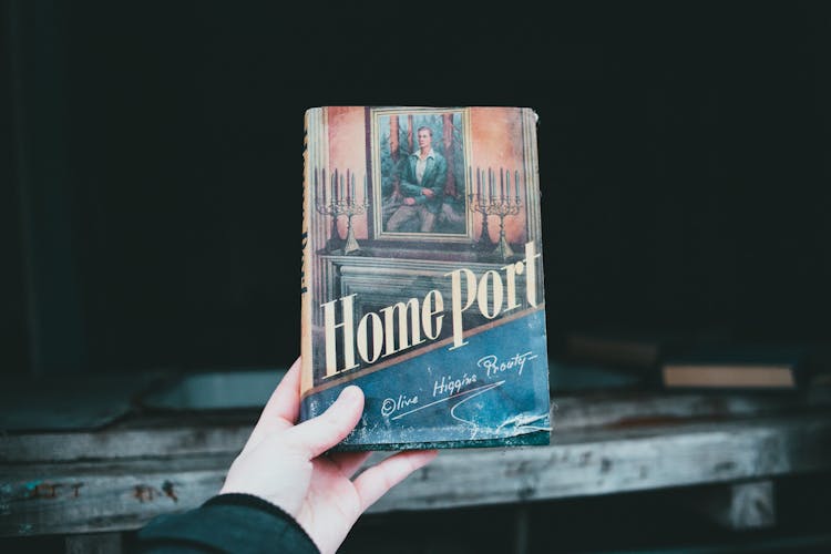 Crop Person Showing Old Book With Inscription