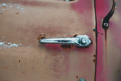 Old vehicle with metal handle on rusty door