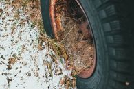 Wheel of old transport on snowy land