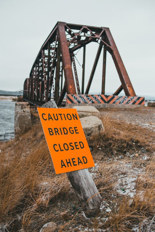Warning sign near bridge over river