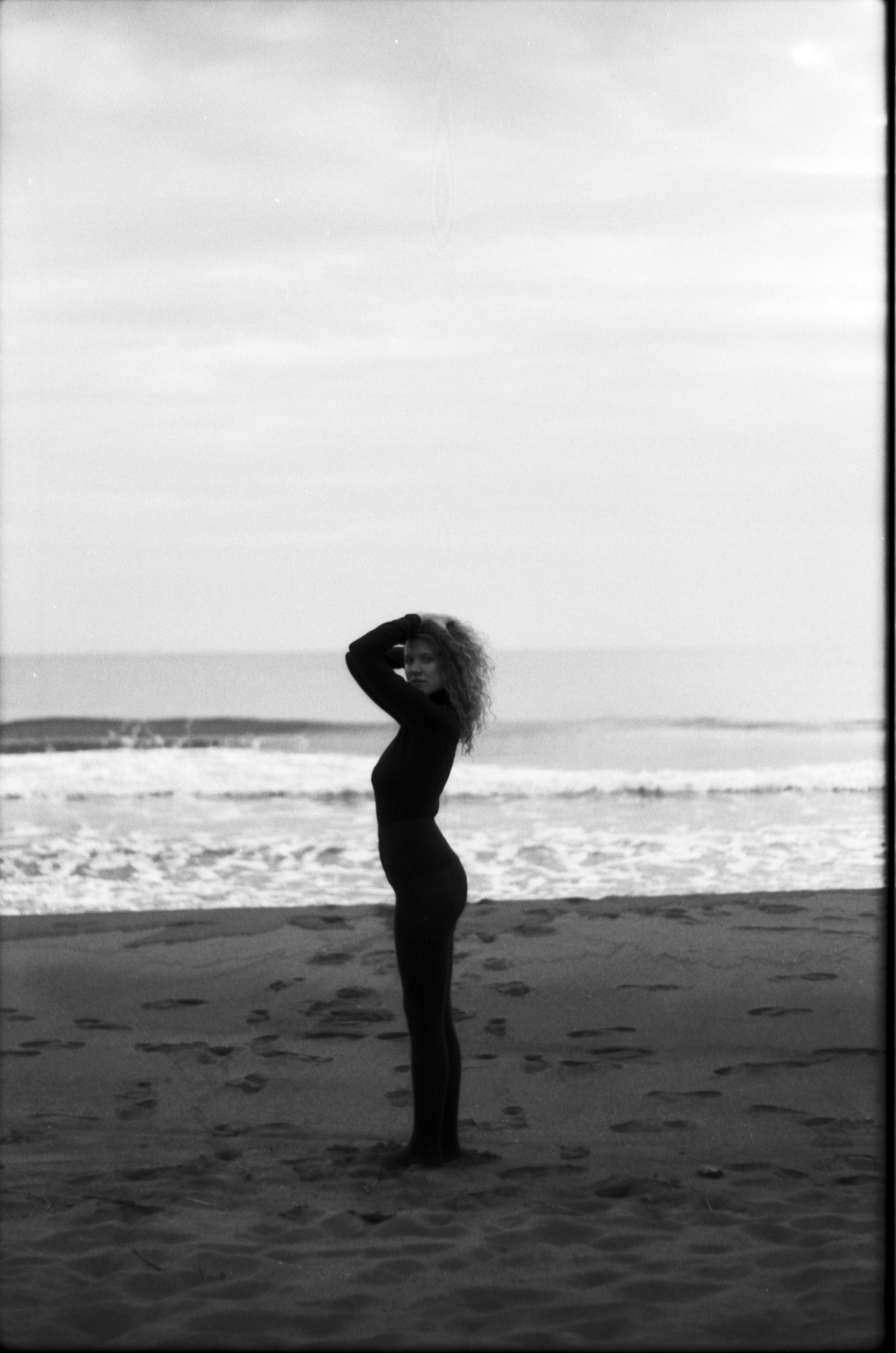 Black and white portrait of a woman posing on a beach in Montenegro.