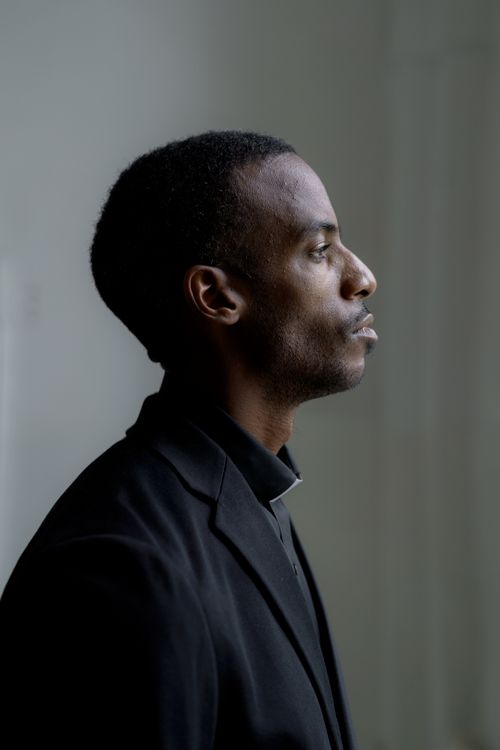 Free Profile portrait of a man in clerical clothing, thoughtful expression, side view indoors. Stock Photo