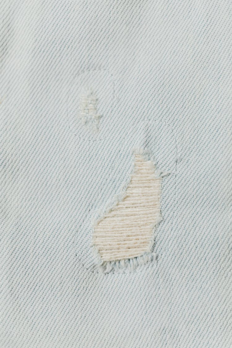 A Close-Up Shot Of A Ripped Denim Fabric