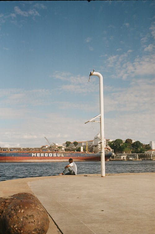 Man Sitting Under the White Lamppost