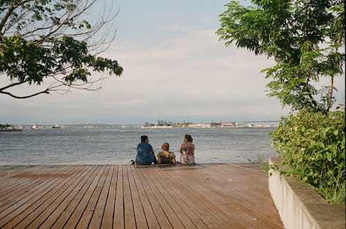 Friends Talking while Sitting on a Wooden Planks