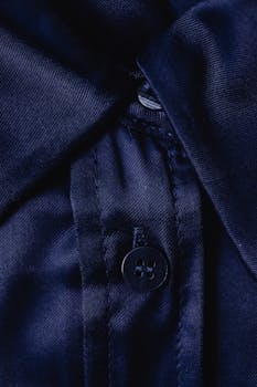 Detailed close-up of dark blue fabric with a four-hole button illustrating texture and craftsmanship.