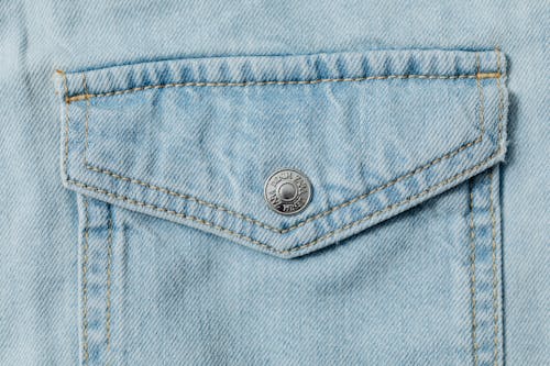 Close-Up Photo of Denim Textile with a Silver Button