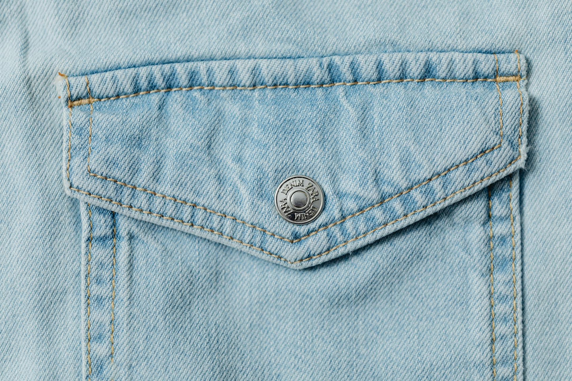 Close-Up Photo of Denim Textile with a Silver Button