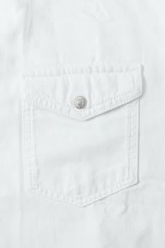 Detailed close-up of a white cotton shirt pocket with button.