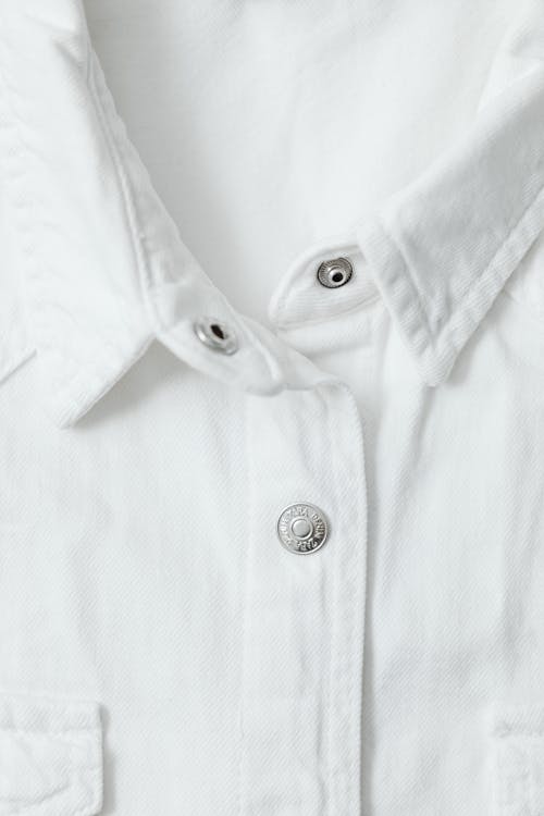 Close-Up Photo of a White Shirt with Silver Buttons