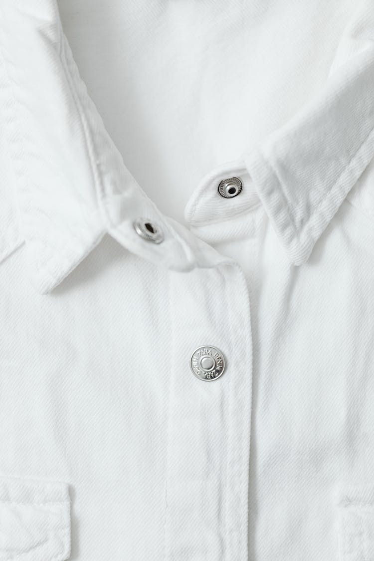 Close-Up Photo Of A White Shirt With Silver Buttons