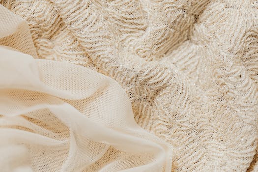 Close-up view of intricate beige lace fabric and sheer material, ideal for fashion and textile projects.