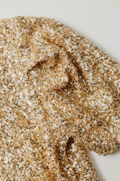 Free Close-up texture of sparkling gold sequin fabric, perfect for fashion and design backgrounds. Stock Photo