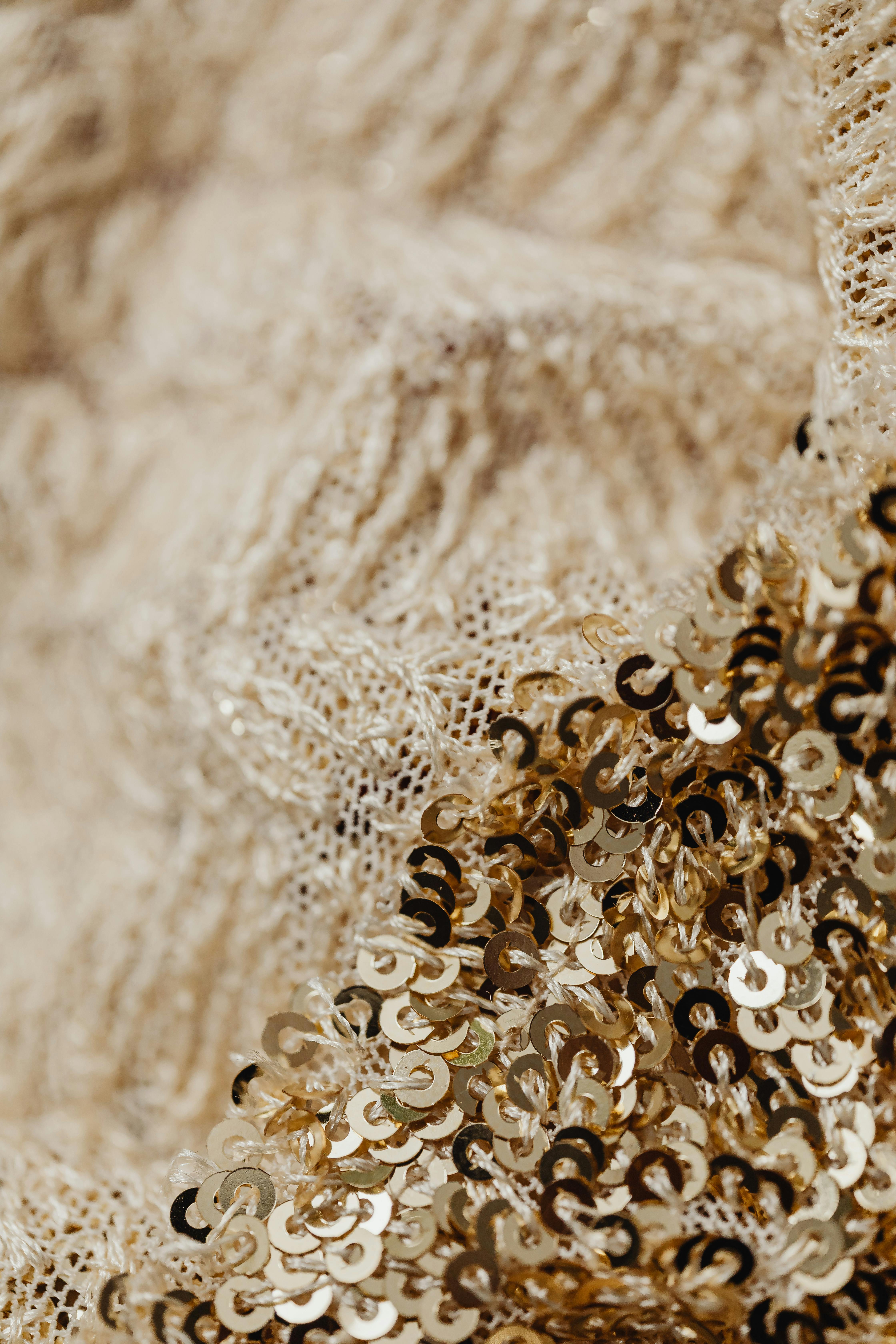 selective focus photo of woven fabric with golden sequins