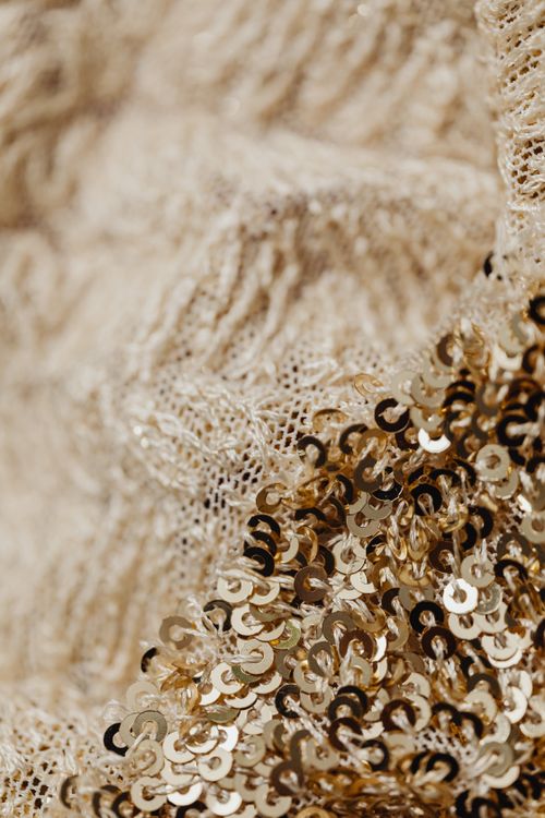 Free Detailed close-up of woven gold sequins and lace fabric for fashion design. Stock Photo
