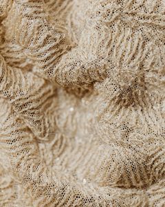 Detailed close-up of textured beige woven fabric with intricate fibers, ideal for textile and design concepts.