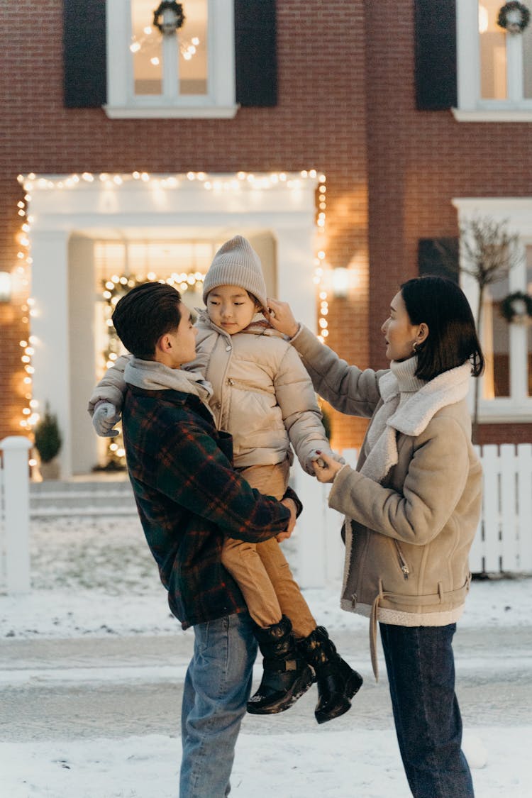 Family Standing Outside Their House During Winter