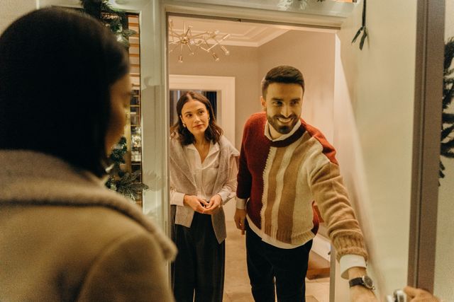 Hosts greeting a guest at the front door — photo by cottonbro studio on Pexels