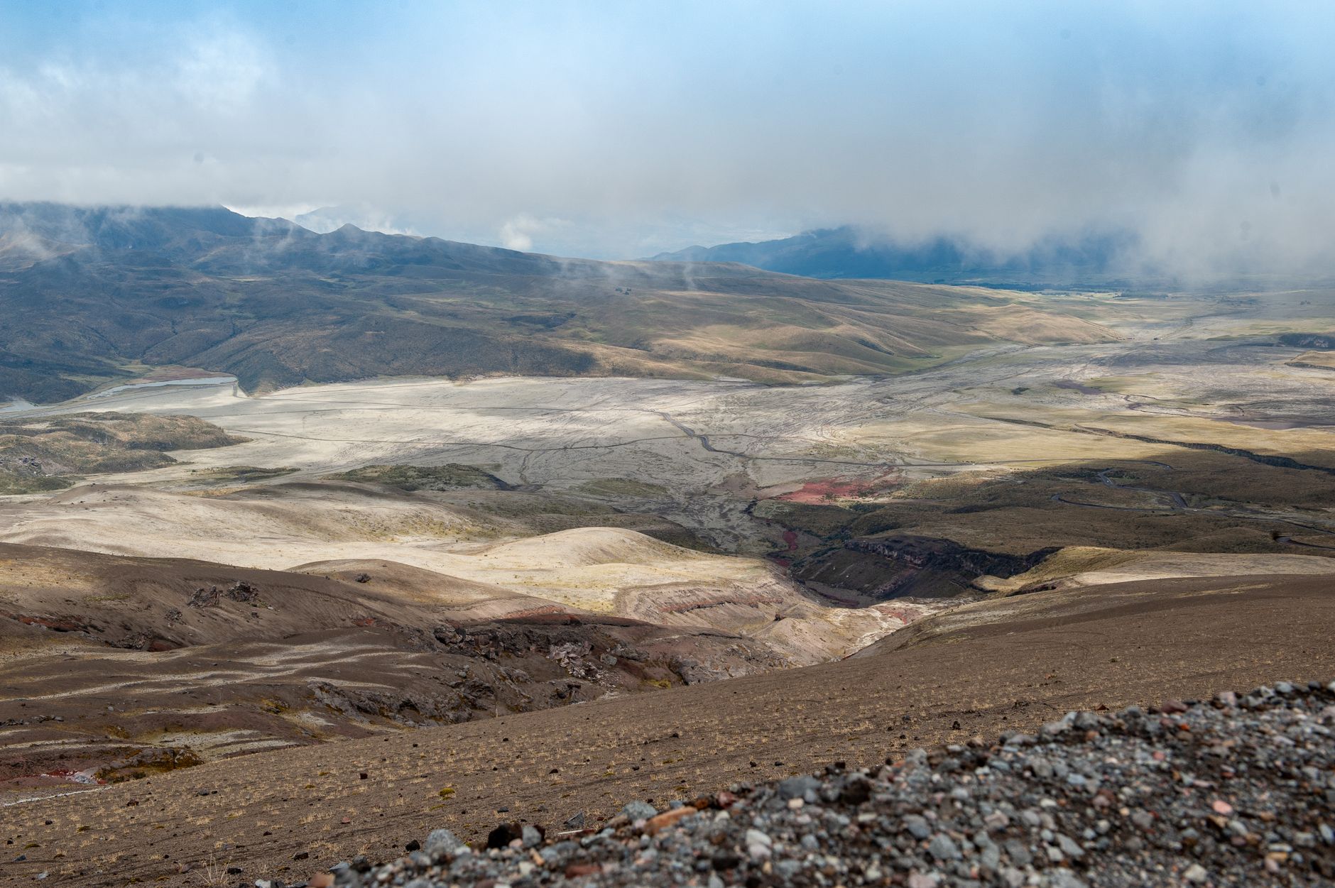 Breathtaking view of Cotopaxi Volcano in Ecuador, showcasing barren, eroded landscapes and clouds.