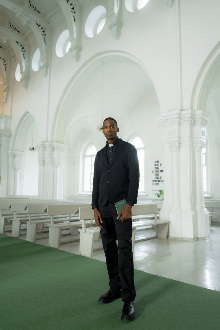 Photograph Of A Pastor Standing Inside A Church