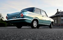 日落时分，一辆老式福特汽车停在城市街道上的低角度镜头