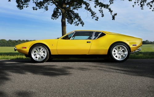 Free Yellow Sports Car Parked Near Green Leafed Tree Stock Photo