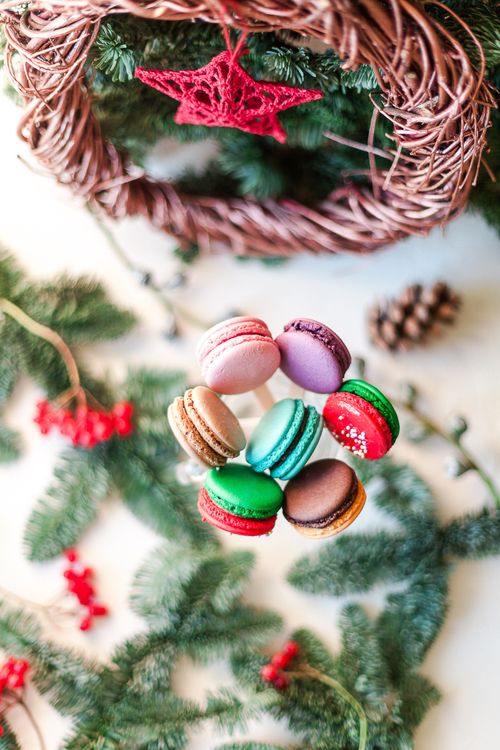 Free Top view composition of delicious fresh macaroons on sticks placed near Christmas decorations and fir twigs Stock Photo