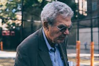 老人在城市户外戴着太阳镜行走