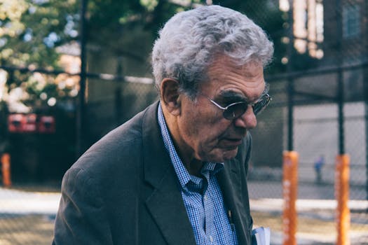 老人在城市户外戴着太阳镜行走