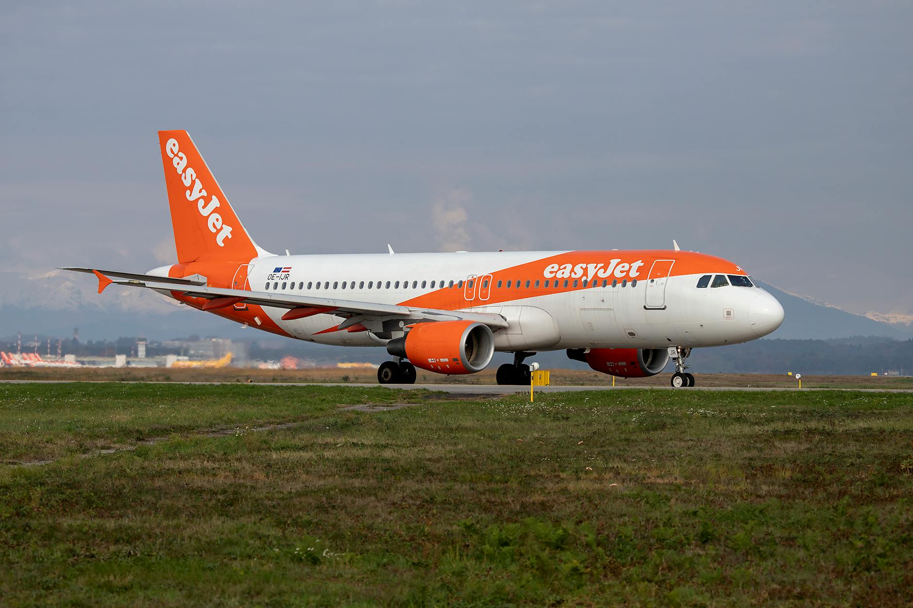 An EasyJet Airbus A320 prepares for departure on a clear day at the airport.
