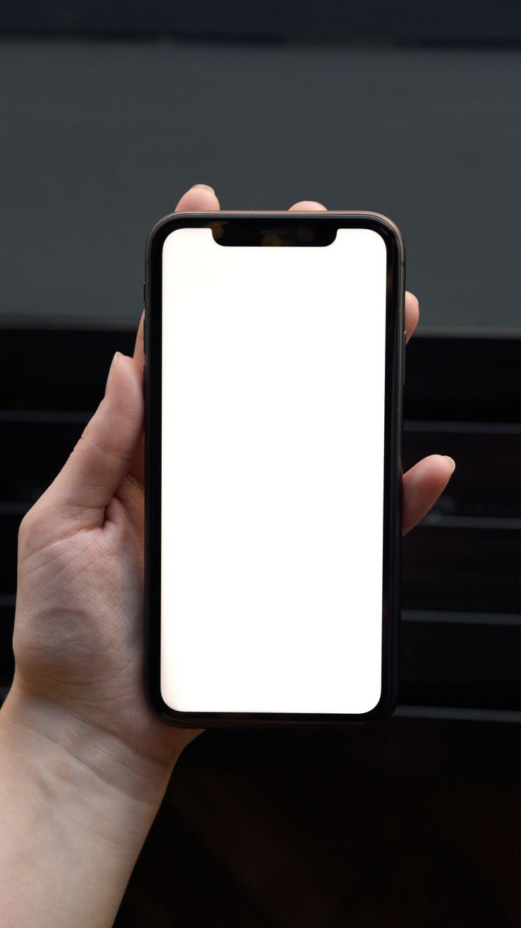 Close-up van een hand die een smartphone met een leeg scherm vasthoudt, ideaal voor mockup gebruik.