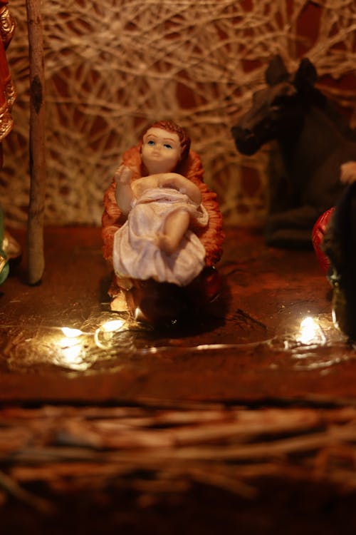 Close Up Photo of a Figurine of Baby Jesus in a Manger