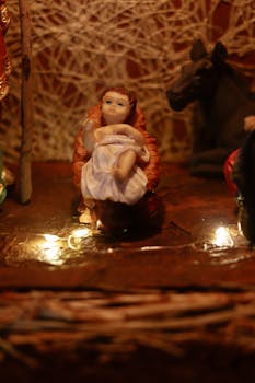 close up photo of a figurine of baby jesus in a manger