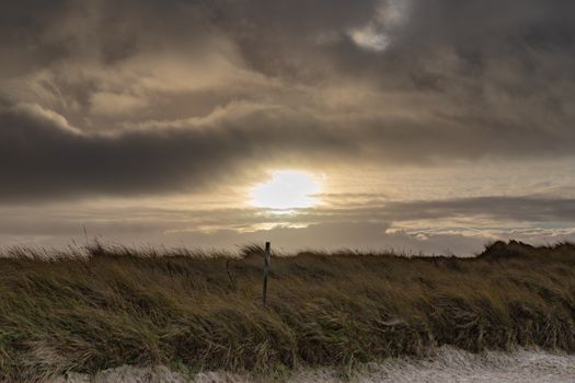 A stunning sunset with dramatic clouds over a grassy field. Perfect for nature and landscape themes.
