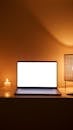 Photo of a Laptop Beside a Lit Candle