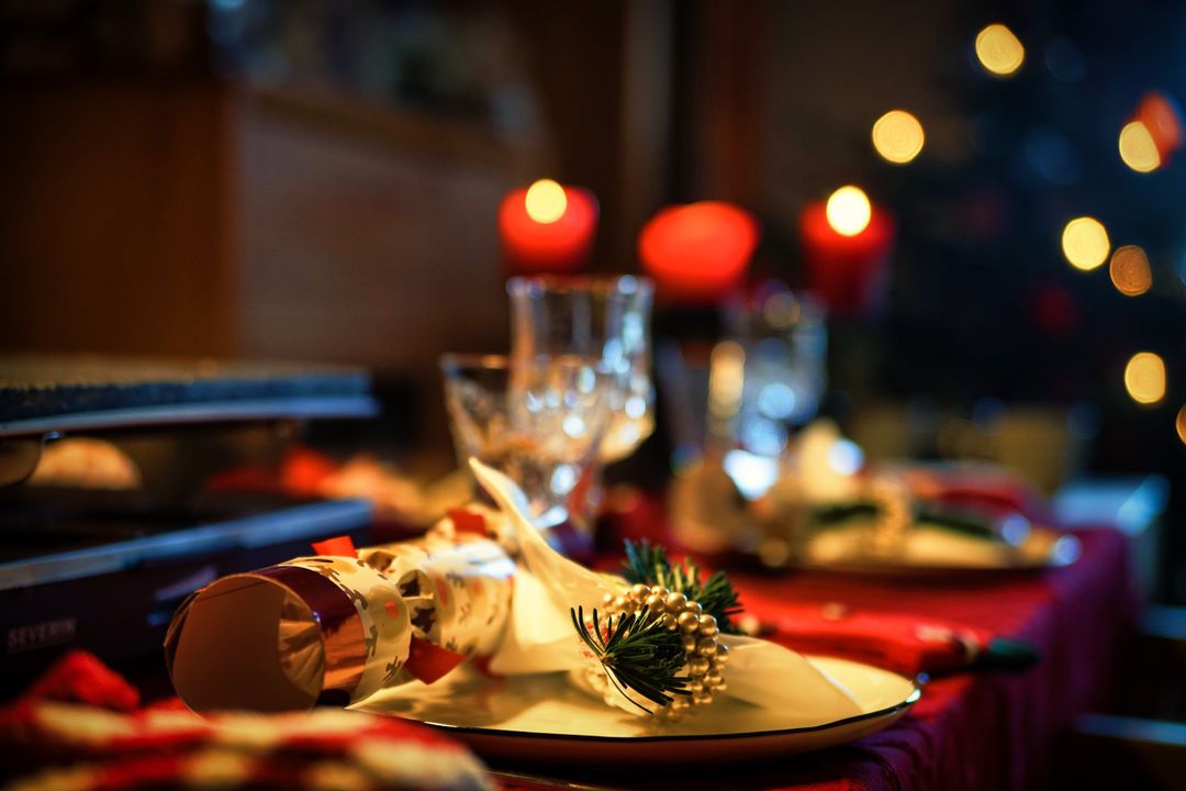 Elegant Christmas dining table with candles, festive decor, and a warm holiday ambiance.