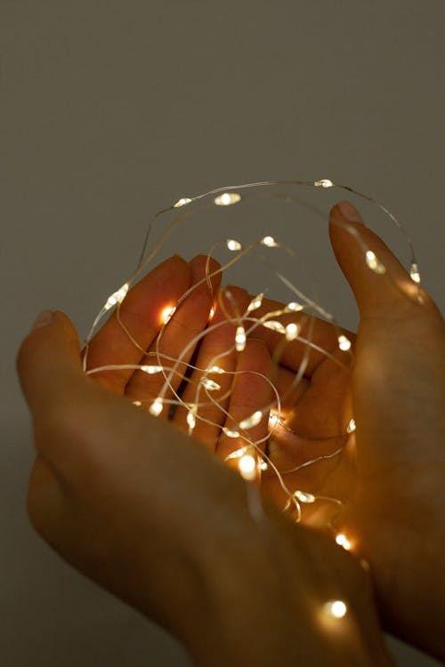 Close-Up Photograph of Fairy Lights on a Person's Hands