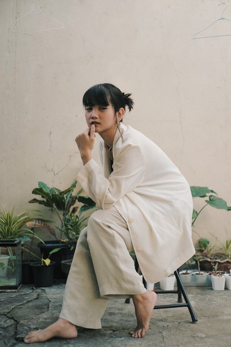 Elegant Asian Female Sitting On Stool In Garden