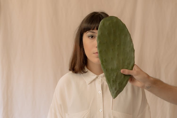 Photo Of A Green Cactus Leaf Near A Woman's Face