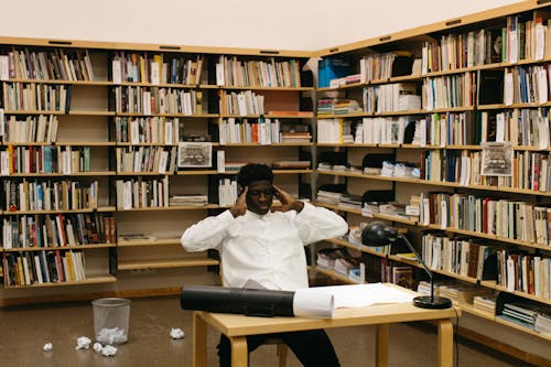 A Man Thinking while Sitting Inside the Library