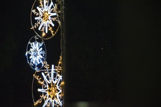 Close-up view of illuminated snowflake decorations during nighttime festivities.